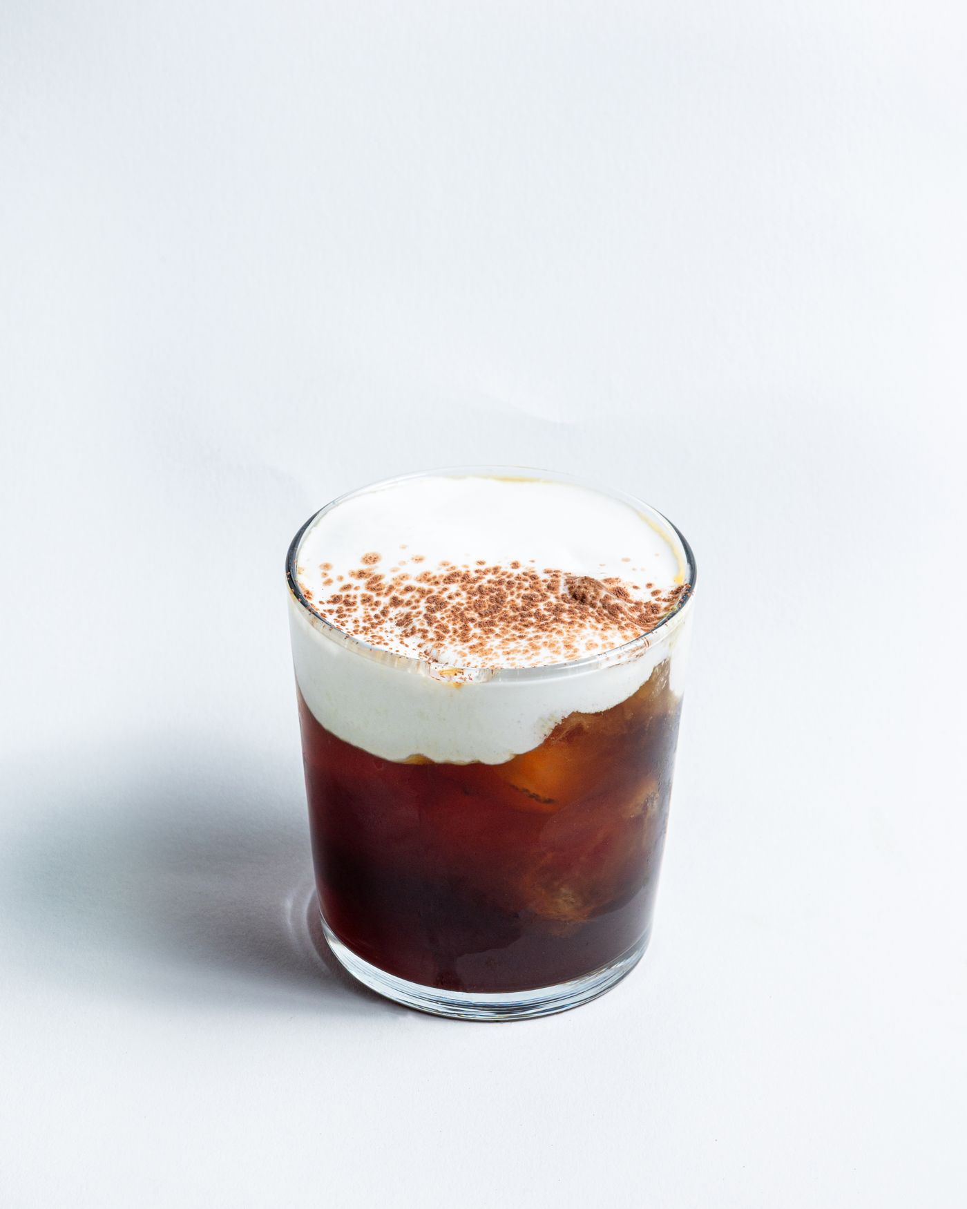 Eiskaffee mit Sahne und Kakaopulver im Glas